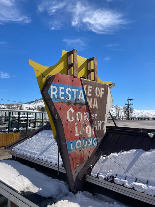 Old house of china sign with coach lite lounge sign under in gunnison, colorado