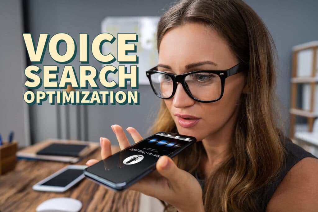 Woman holding phone up to ask the voice assistant a question. Woman has glasses and the words "Voice Search Optimization" are in yellow next to her head.